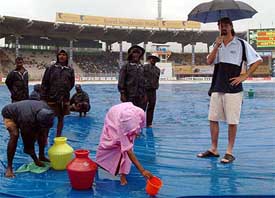 Australias Jason Gillespie watches ground staff at work on the fifth day of the second Test at the MA Chidambaram Stadium in Chennai
