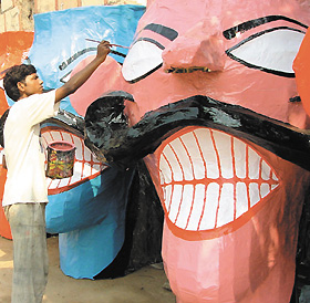 An artist gives finishing touches to an effigy of Ravana for the Dashera festival in the Capital on Wednesday