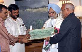 Prime Minister Dr Manmohan Singh receiving the dividend cheque of Rs 56.45 crore of Kribhco from Union Minister of Chemical, Steel and Fertiliser Mr Ram Vilas Paswan