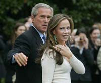 President George W. Bush walks to the Marine One helicopter with one of his twin daughters