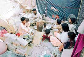 Dhuni Parsad with his family in their demolished house in Model Town Extension in Ludhiana on Saturday