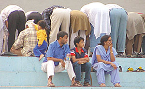 Spectators take time out to offer namaz at Ambedkar Stadium, where a Santosh Trophy match was on in the Capital on Sunday.