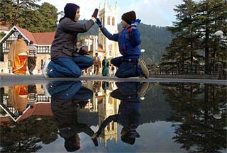 Tourists have a nice time at the Ridge following a heavy shower in Shimla on Sunday