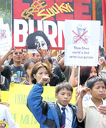 Myanmarese children wave an anti-government placard as they demonstrate against their countrys leader General Than Shwe's visit to India in the Capital on Tuesday
