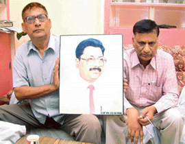 Family members with a photograph of Naresh Mahajan