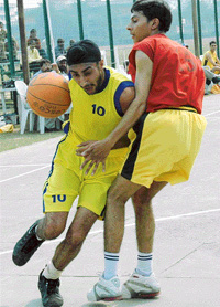 A Punjab Technical University player being checked by a GB Pant University player during an inter-university basketball match at Panjab University in Chandigarh, on Wednesday.