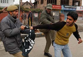 Policemen try to overpower an activist of Tehreek-e-Hurriyat during a protest demonstration in Srinagar