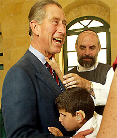 Britain's Prince Charles is embraced by 12-year-old handicapped Mohammad Maher during his visit to the Salt Training and Resource Institute for the disabled in the Jordanian town of Salt on Wednesday