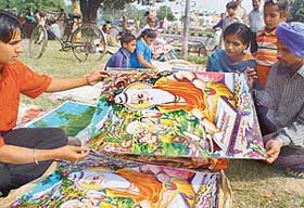 Devotees select a poster of Maharishi Valmiki on Valmiki Jayanti at Sector-24, Chandigarh