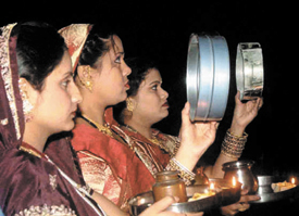 Women having a dekko at the moon before ending their fast on the occasion of Karva Chauth in the Capital.