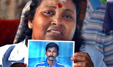 Darien Rita Rajaratnam, wife of Sri Lankan truck driver Dinesh Dharmendra Rajaratna shows his photographs at their home in Wattala, a suburb of Colombo