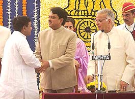 Maharashtra Chief Minister Vilas Rao Deshmukh greets his deputy, NCP leader R. R. Patil, after being sworn in, as Governer Mohamed Fazal looks on at Raj Bhavan in Mumbai on Monday.