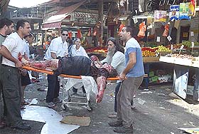 Israelis help a wounded woman after a blast in Tel Aviv's market on Monday. At least four persons were killed and several wounded in an explosion in Tel Aviv's main open-air market, the fire brigade said. 