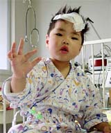 Yuta Minagawa, a two-year-old boy who was rescued after being buried for four days by Japan's deadliest earthquake in a decade, gestures at Nagaoka Red Cross Hospital in Nagaoka, 250 km north of Tokyo, on Sunday.  