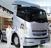 Models stand beside the Mitsubishi Fuso Truck and Bus Corps newly-developed concept truck Fuso Concept at a press preview for the 38th Tokyo Motor Show in Makuhari, east of Tokyo on Tuesday. The 38th Tokyo Motor Show, featuring commercial and barrier-free vehicles, opens to the public on Wednesday.