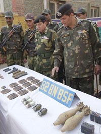 Border Security Force officers look at the arms and ammunition seized during a raid in Srinagar on Tuesday. 