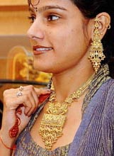A woman wears a gold necklace at a jewellery shop in Agra on Tuesday