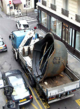 An artists rendering of a giant Nazi-era German Army helmet is transported by truck through Le Marais