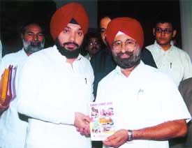 Mr N.S. Nanda, president of the Hotel and Restaurant Association of Punjab, presents a tourist directory of the state to the Delhi Tourism Minister