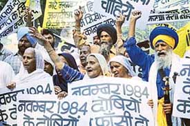 Sikhs shout slogans while carrying placards during a protest rally in New Delhi on Friday. They were demanding execution of those involved in the riots in 1984.