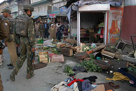 BSF personnel examine the site where militants hurled a grenade on a patrol party killing two soldiers in Srinagar on Saturday. 