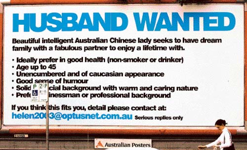 A woman walks past a billboard that Shanghinese woman Helen Zhou placed in search of a husband in Sydney