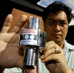 A Filipino inventor Glen Castillio shows a universal fuel expander for unleaded gas and diesel in Manila on Sunday. Castillios claims his expanders can save 10 to 20 per cent of fuel on city driving and up to 50 per cent on highways with a Do-it-Yourself manual.