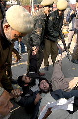 Policemen arrest Hurriyat Conference activists during a demonstration in against the alleged rape of a woman and her daughter