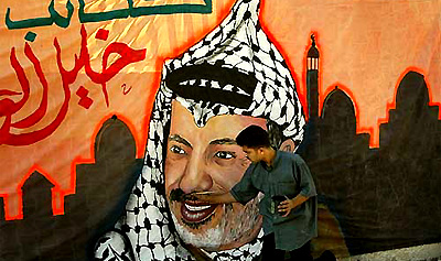 A Palestinian artist paints a large banner of President Yasser Arafat in Gaza 