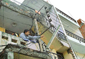 A resident of Sector 15 Housing Board Colony stands in his balcony, with an 11 kv cable dangerously close.