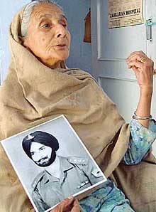 Surjit Kaur with a photograph of her husband Captain Bhajan Singh, missing since the 1971 war, in Mohali on Wednesday.
