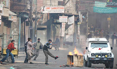 Kashmiri youths pelting stones at a police vehicle during a violent demonstration against the rape of a woman-daughter duo at Handwara in central Srinagar on Wednesday.