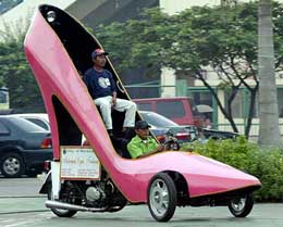 A Filipino makes a turn while testing a 1,000 cc Japanese motor cycle made into a giant ladies shoe at a busy street of Marikina city, east of Manila, on Thursday. 