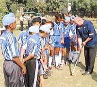 Chief coach of Indian hockey Gerhard Rach gives tips to trainees of St Stephens School, Sector 45, Chandigarh, during the Molly Carver Sports Carnival on Thursday