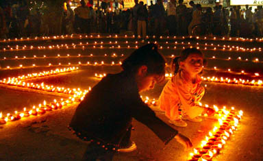 Little girls light diyas at the Sector 17 Plaza, Chandigarh, during the Divali celebrations