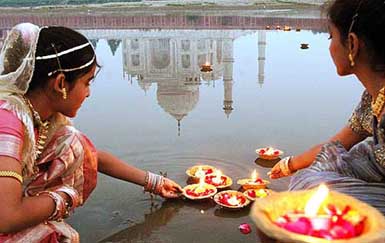Girls place oil lamps on the waters of the Yamuna behind the Taj Mahal on the eve of Divali in Agra on Thursday.