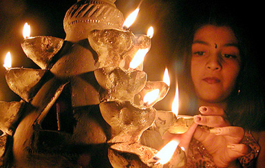 A girl lights diyas on the eve of Divali in Ahmedabad 