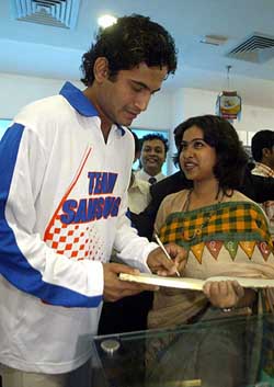 Speedster Irfan Pathan gives an autograph to a fan during a promotional campaigning in Kolkata on Thursday
