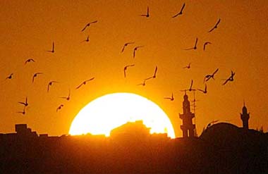 The sun sets behind minarets of Abdoun's mosque in Amman 