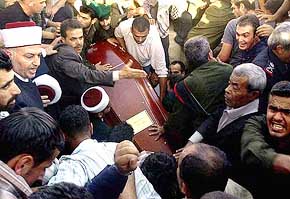 The coffin containing the remains of Palestinian leader Yasser Arafat is lowered into the grave in the West Bank city of Ramallah on Friday.