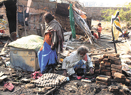 A family trying to retrieve its belongings from a gutted jhuggi at Sarai Kale Khan in the Capital on Sunday.