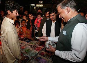 Pakistani Prime Minister Shaukat Aziz buys bangles for his wife during shopping for Id in Islamabad on Saturday. 