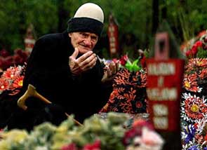 A man visits the grave of a relative, killed during a massacre by Serbian forces in January 1999, at a village near Pristina, Kosovo, on Sunday