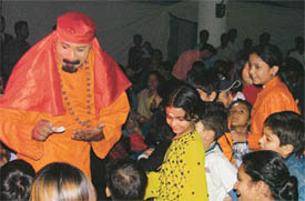 Magician Samraj applies ‘tilak’ on the foreheads of children with magic ash he produced from air