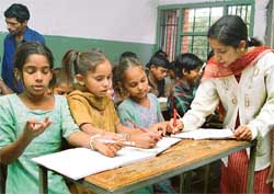 Geeta (right) busy teaching slum children in the Theatre Age-run school on the premises of Government High School, Sector 24, Chandigarh. 