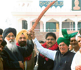 Haryana Chief Minister Om Prakash Chautala and Parkash Singh Badal display the sword of Sir Chhotu Ram at the Wagah checkpost in Amritsar on Wednesday.