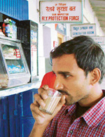 A passenger sips tea in a glass instead of 'kullad' at the railway station in Chandigarh on Thursday.