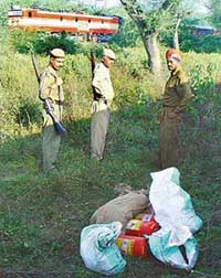 Railway police personnel guard the fire extinguishers found on the Kalka-Ambala railway line near Dera Bassi on Thursday night. 