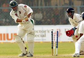 South African batsman Andrew Hall is bowled by Anil Kumble as Indian wicketkeeper Dinesh Karthick looks on during the second days play of the first Test in Kanpur on Sunday