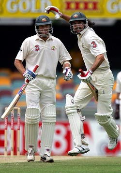 Australian tail-ender Glenn McGrath watches fellow Australian pace bowler Jason Gillespie celebrate his first-ever Test half-century